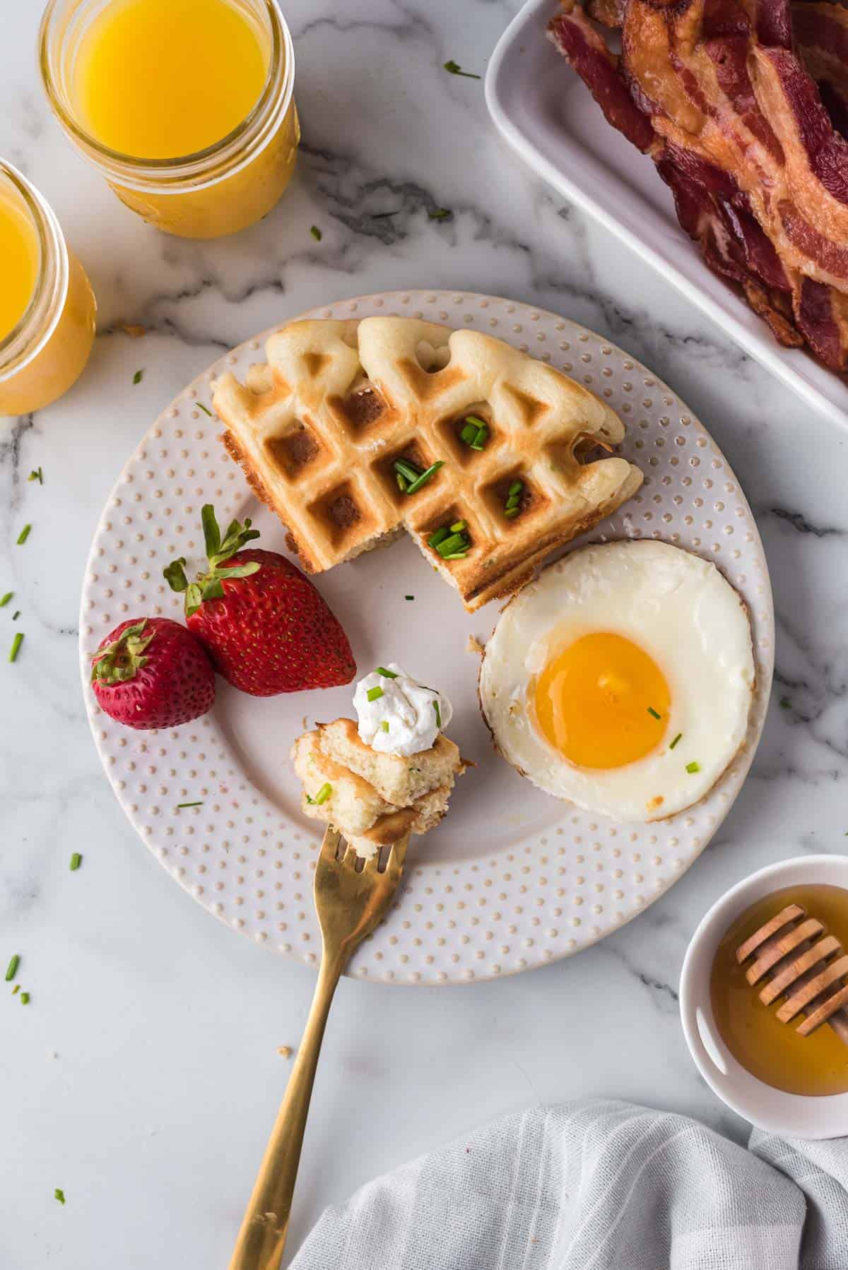 Goat cheese waffles and extra goat cheese on a fork.