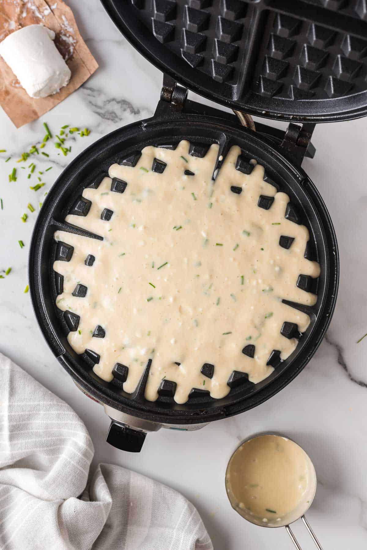 Waffle batter in a round waffle iron.