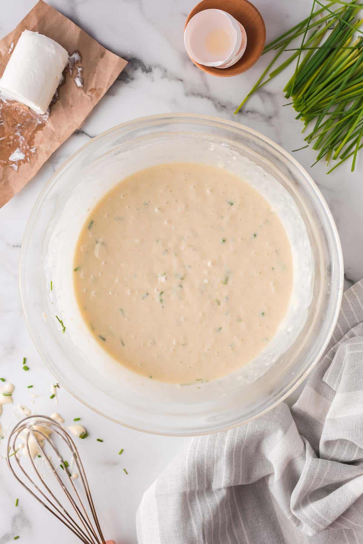 Overhead view of goat cheese waffle batter in a bowl.