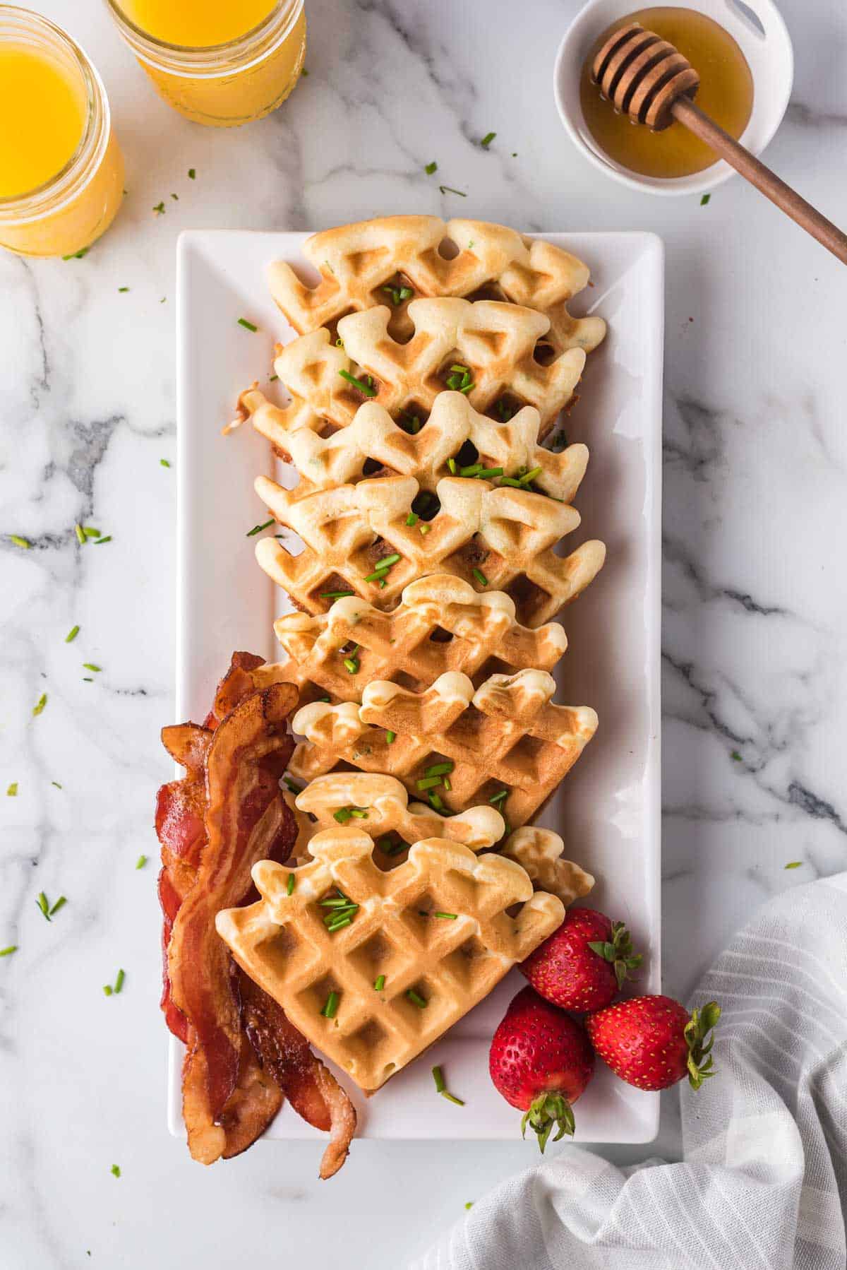 Savory waffles on a tall, thin white platter.