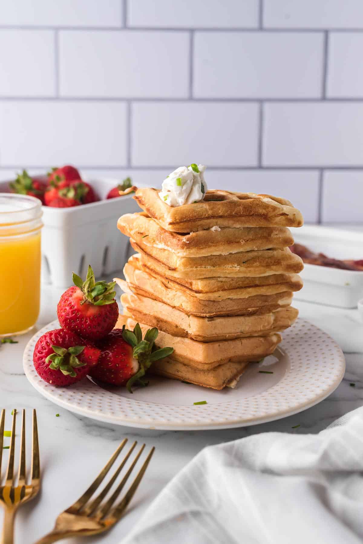 Savory waffles stacked up on a plate.