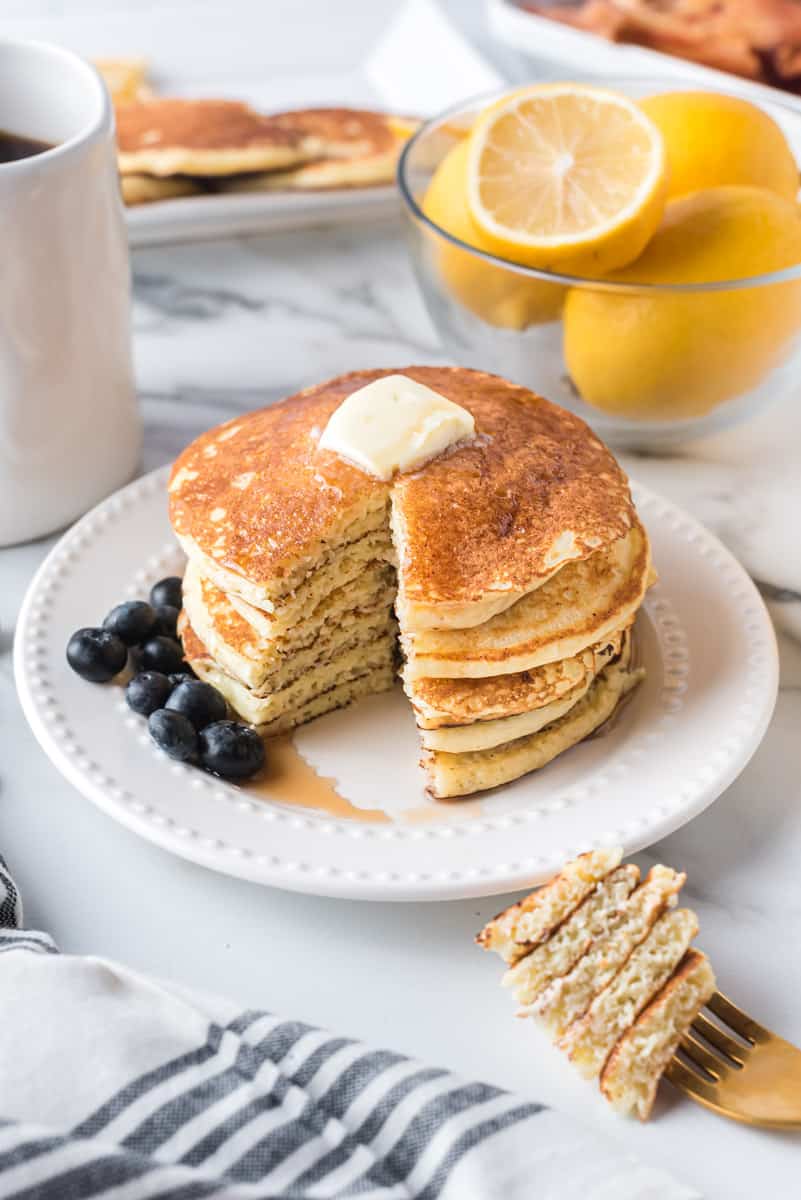 Stack of pancakes with a slice cut out.