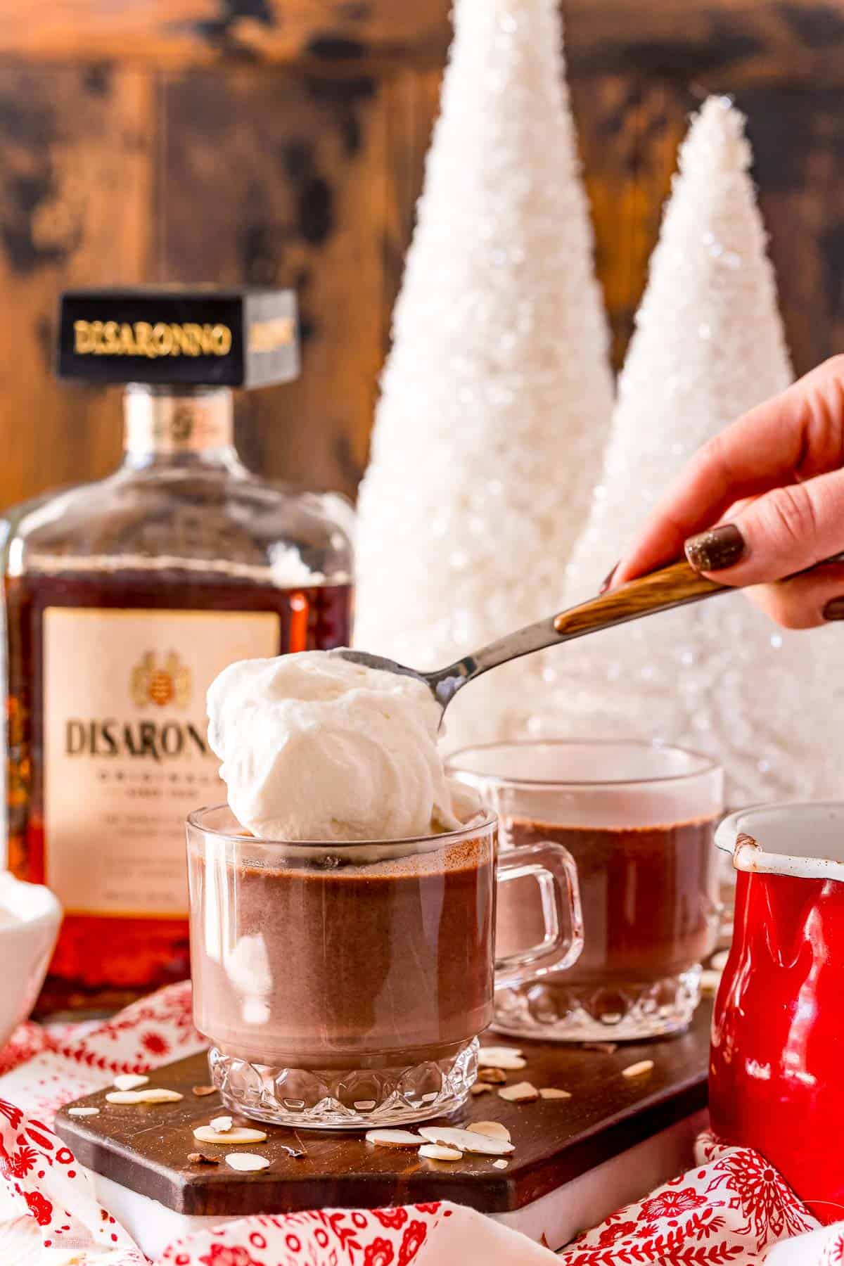 Whipped cream being added to hot chocolate.
