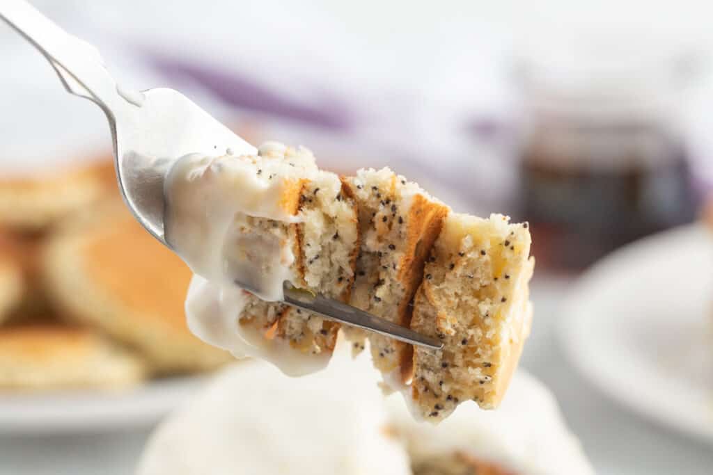 Lemon and poppy seed pancakes on a fork, with a white glaze.