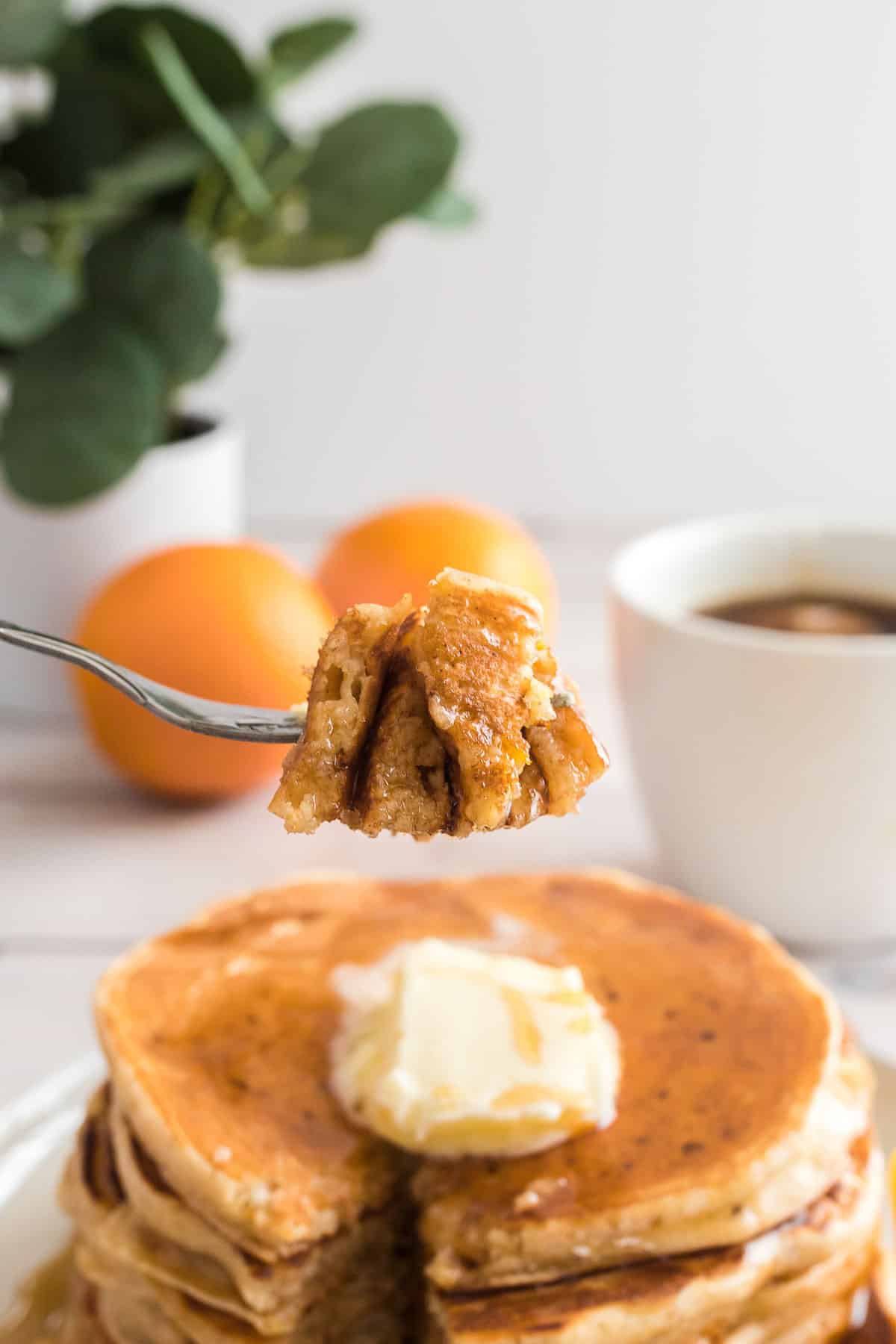 Pancakes on a fork, with more in the background.