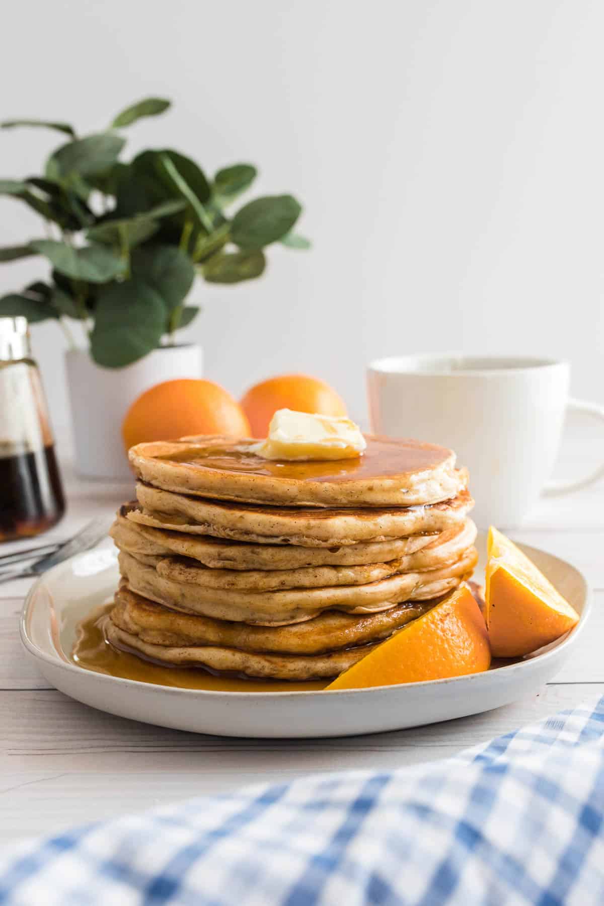 Stack of orange pancakes on a white plate.