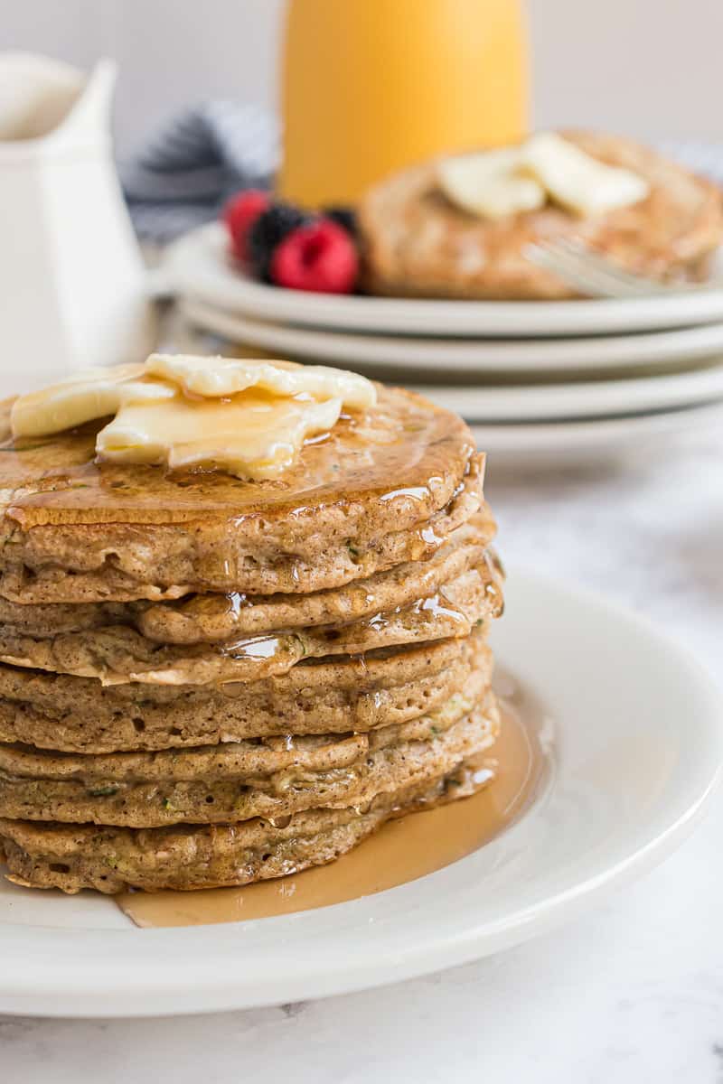 Stack of zucchini bread pancakes with butter and syrup.