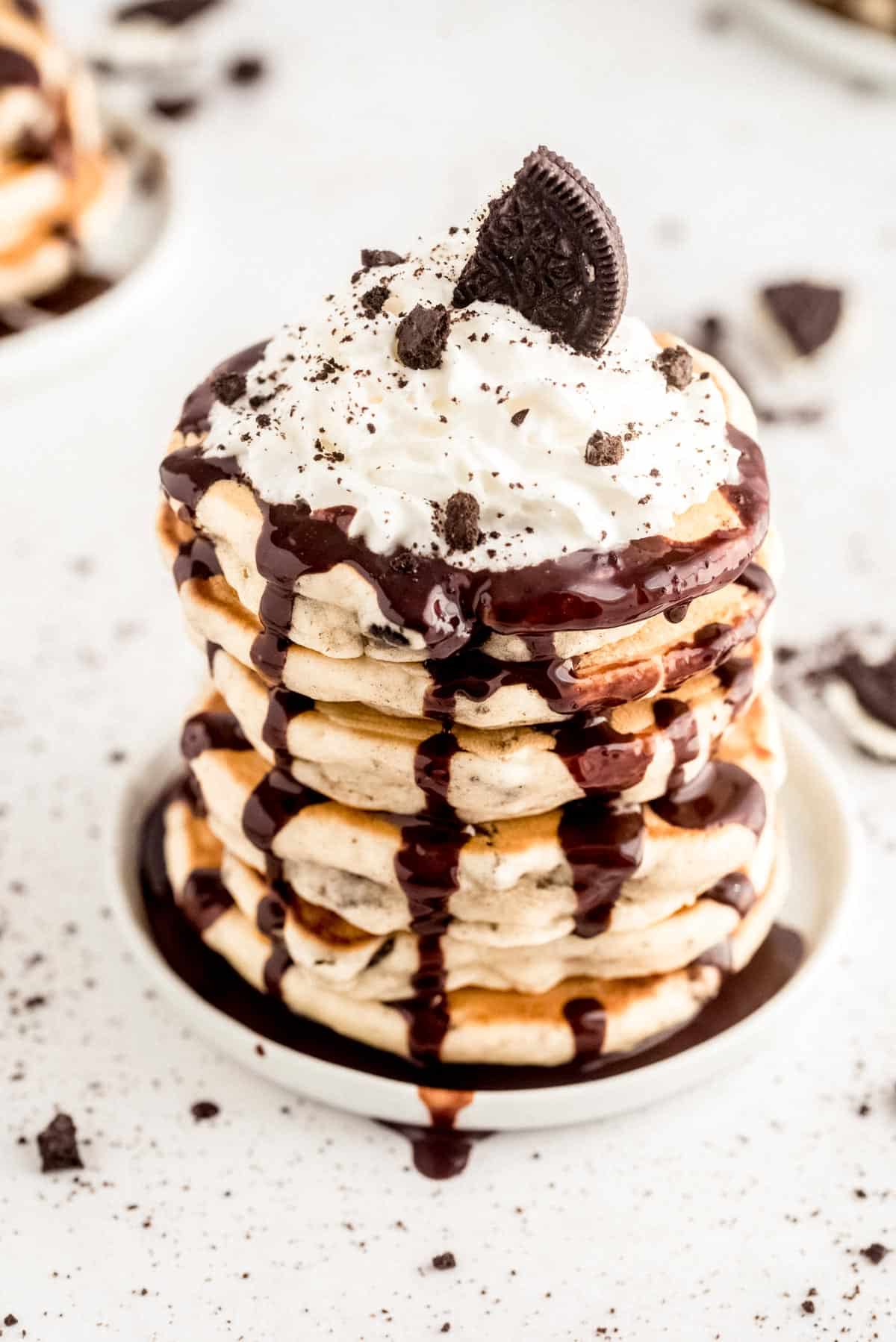 Stack of pancakes flecked with chocolate cookies.