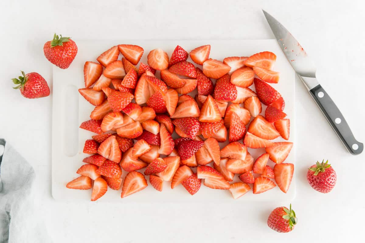 Cut berries on a cutting board.