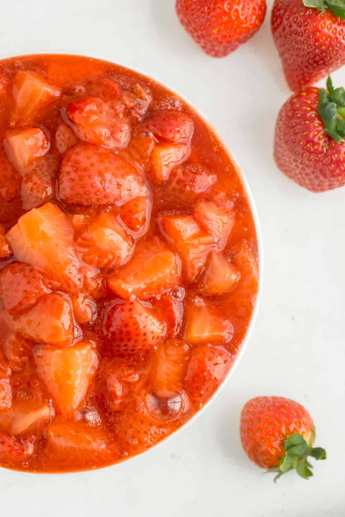 Close up of strawberry sauce in a white bowl.