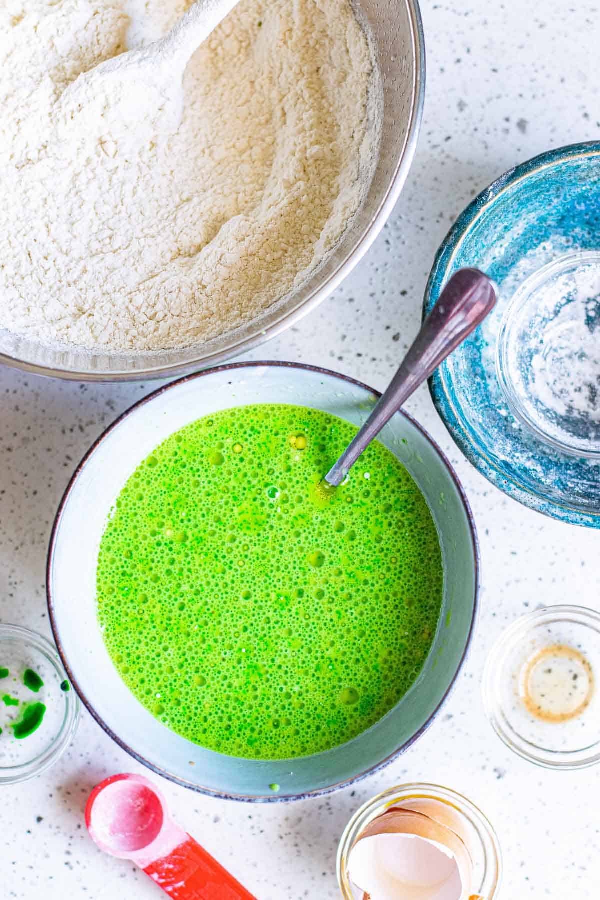 Wet ingredients for bright green pancakes in a mixing bowl.