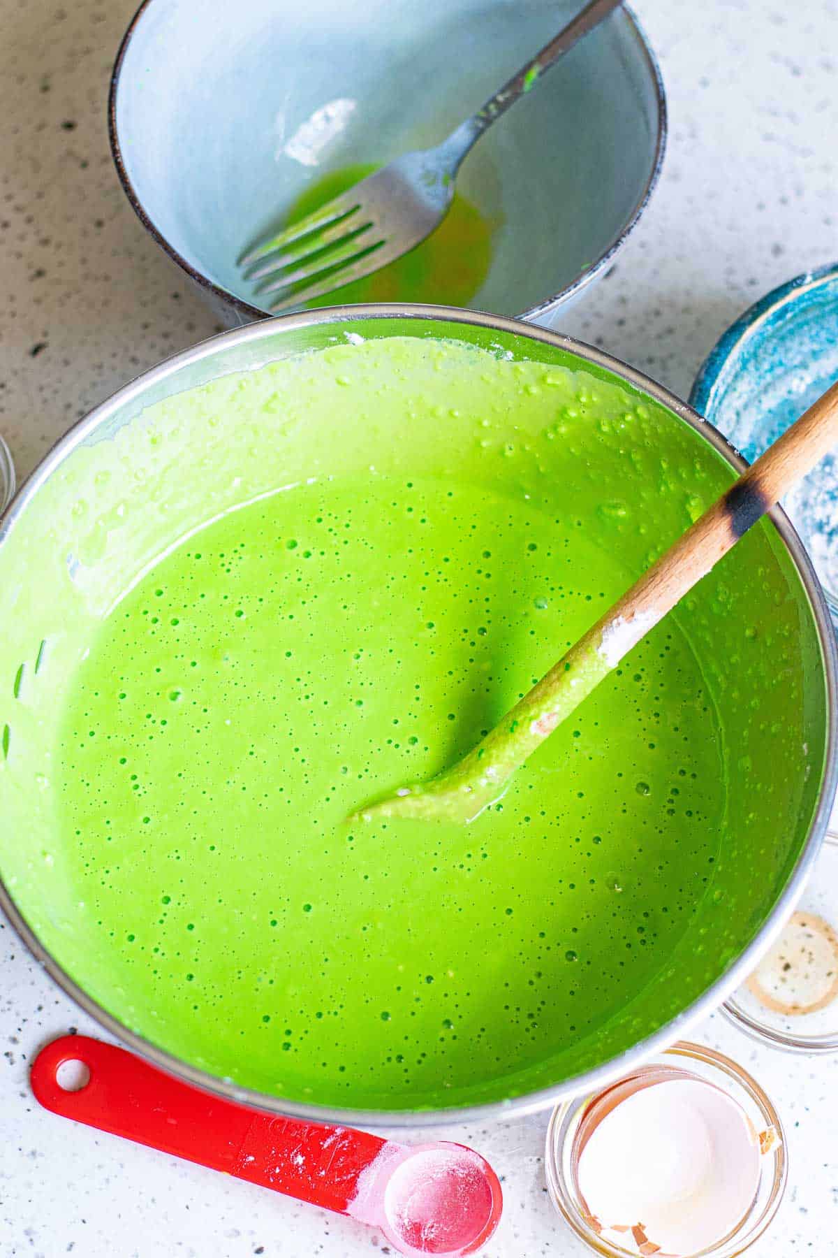 Bright green pancake batter in a mixing bowl.