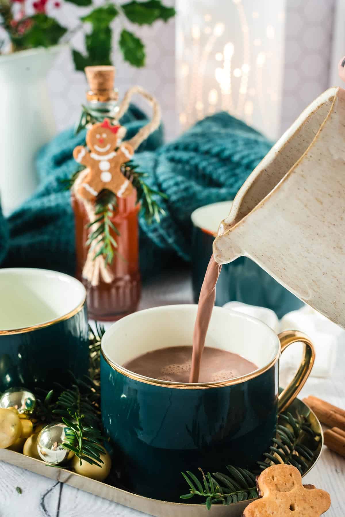 Cocoa being poured into a green mug.