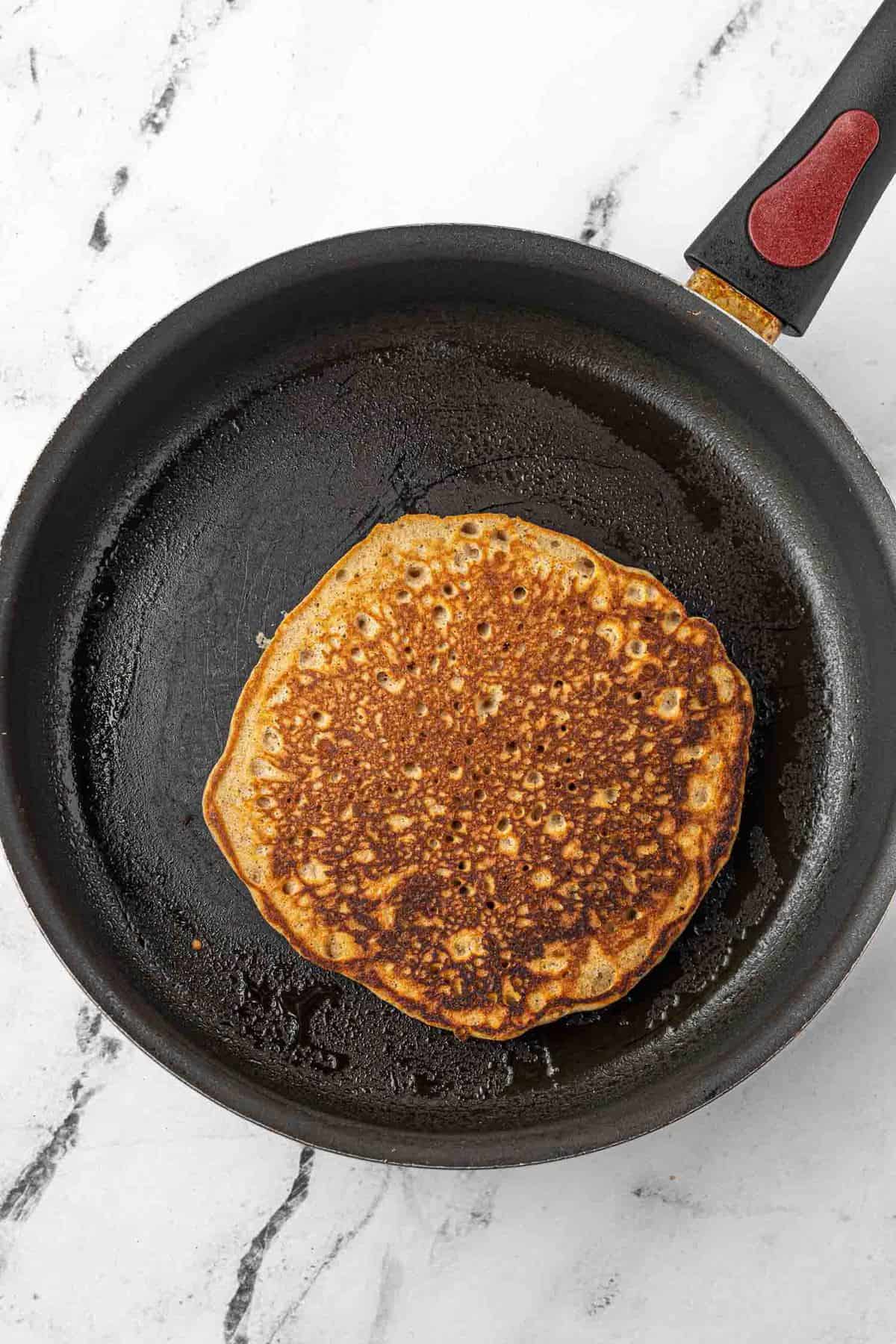 Cooked pancake in a skillet.