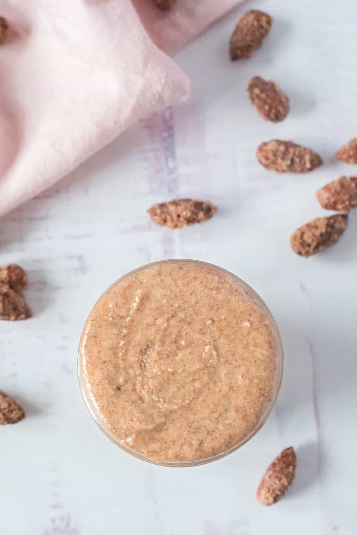 Overhead view of nut butter in a small jar.