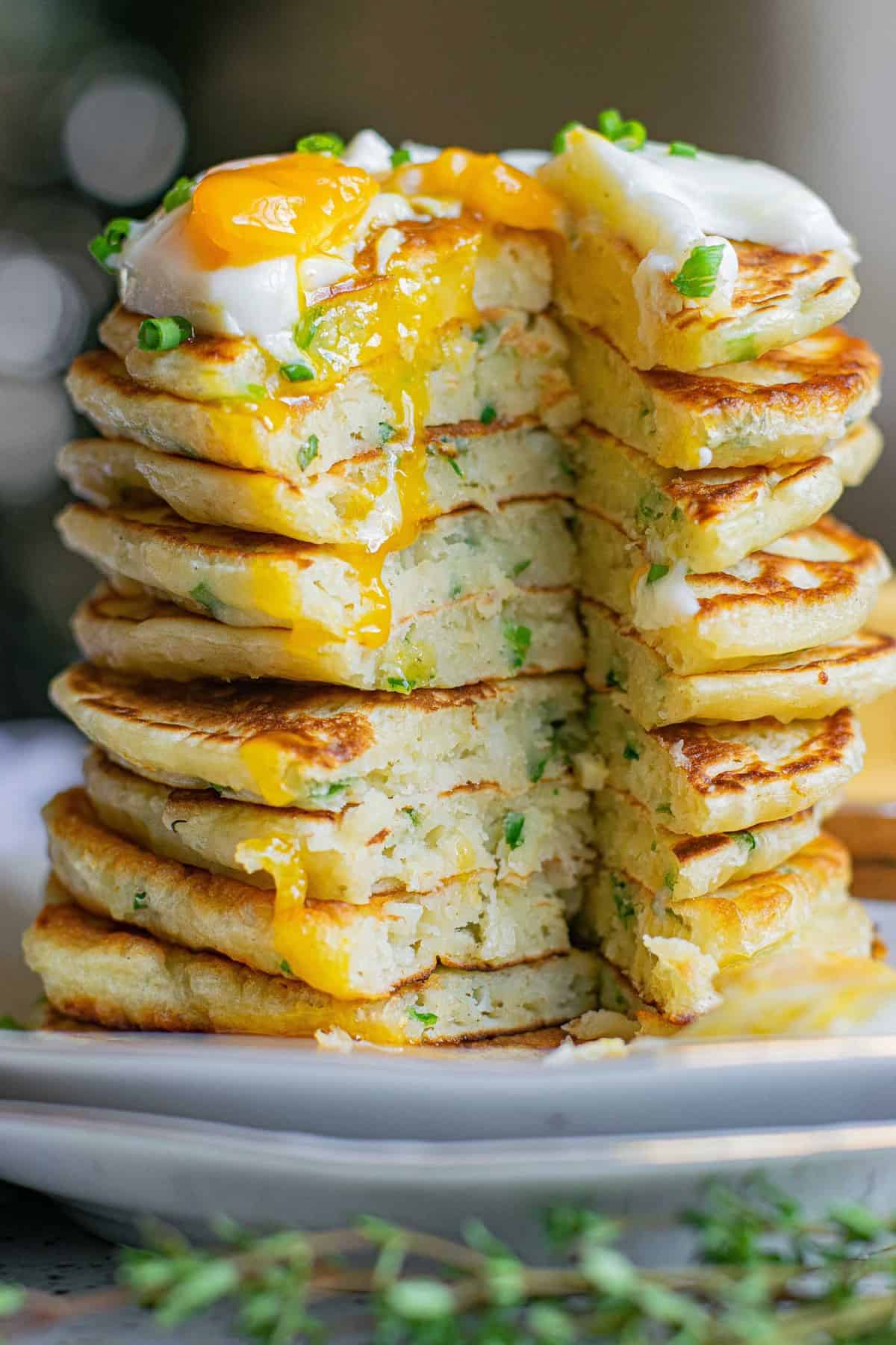 Cut stack of pancakes to show inside texture, egg on top.