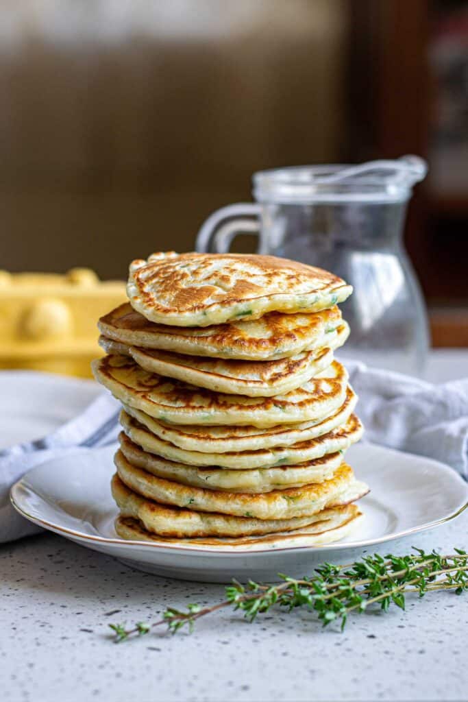 Homemade pancakes cooking on a non-stick skillet with a wooden spatula.