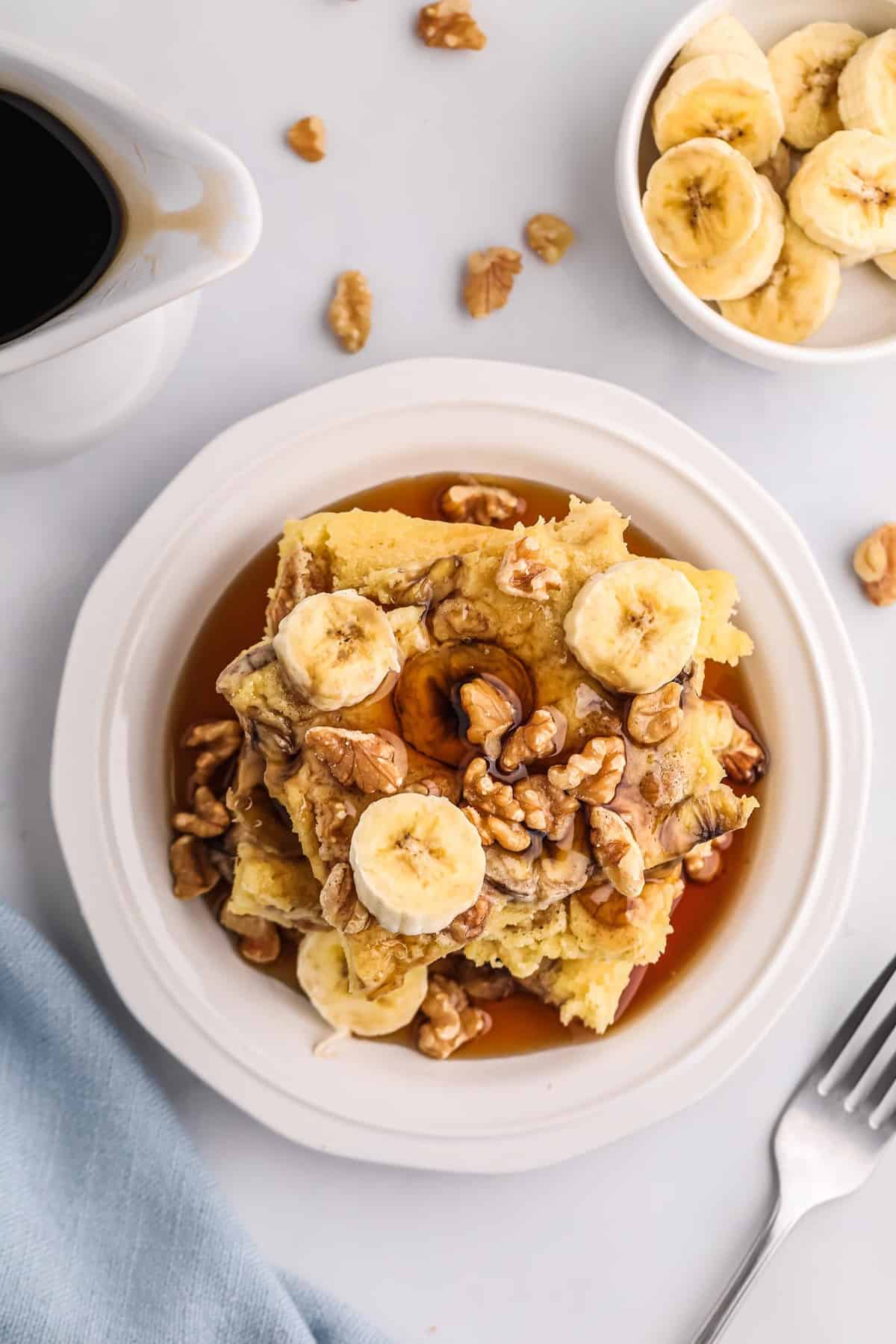 Overhead view of square pancakes topped with bananas and walnuts.