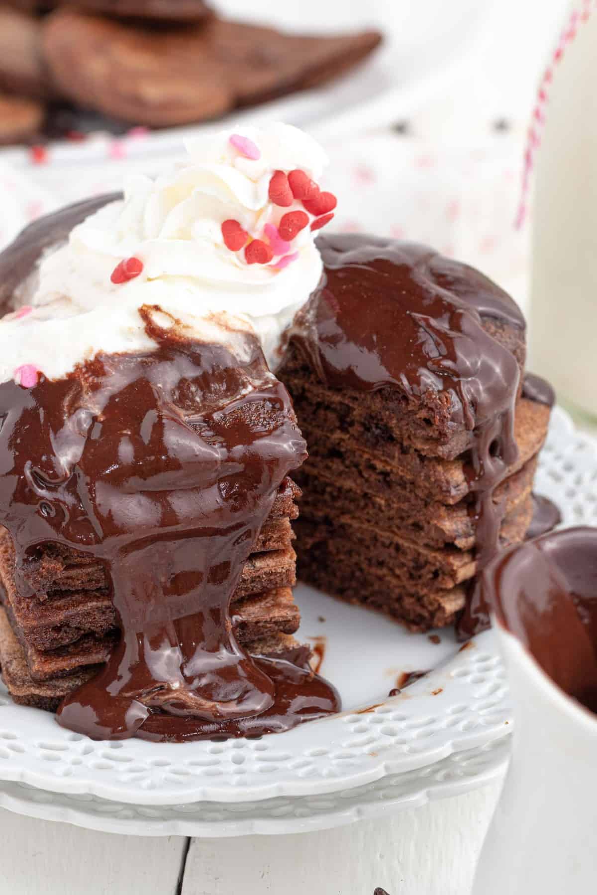 Stack of chocolate pancakes with a cut removed.