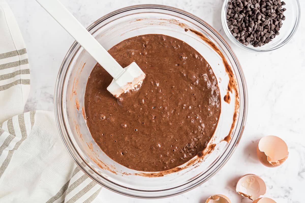 Chocolate pancake batter in a clear glass mixing bowl.