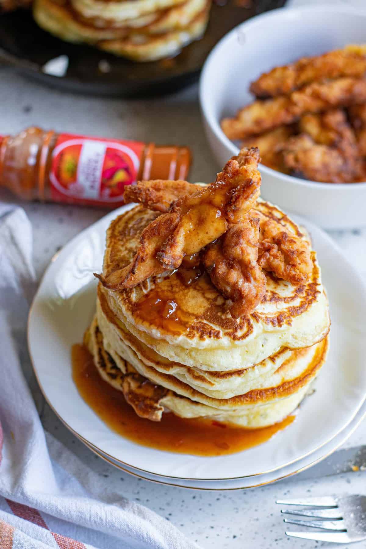 A stack of pancakes, topped with hot, crispy chicken.