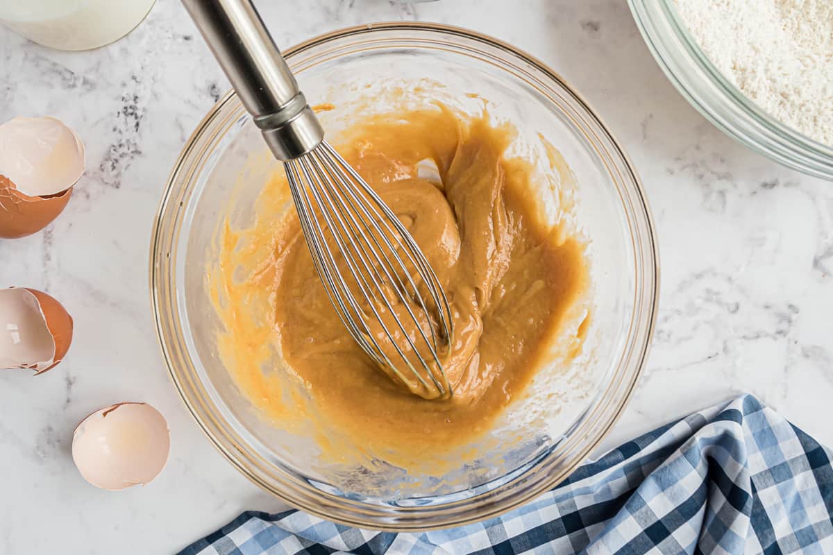 Peanut butter, eggs, and oil mixed together with a wire whisk.