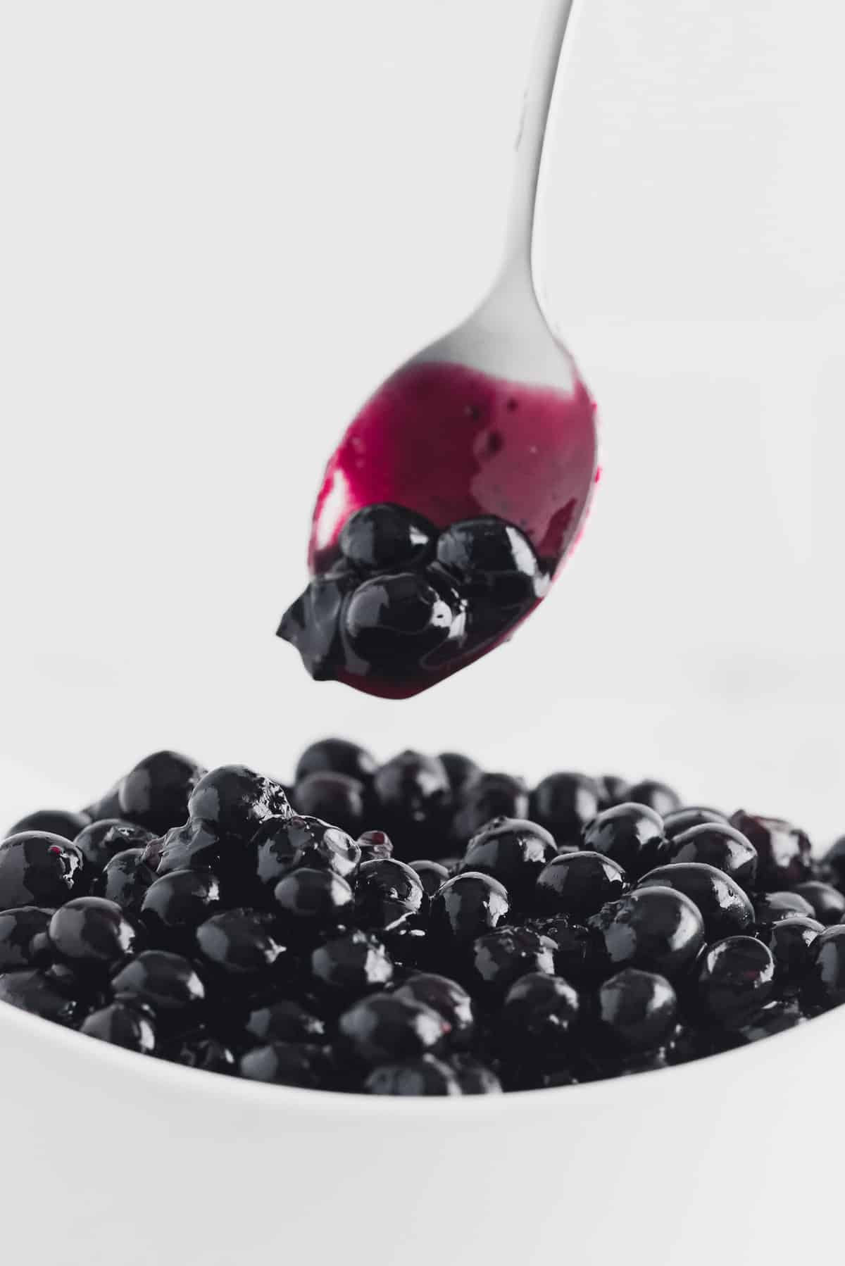 Blueberry sauce in a bowl and on a spoon.