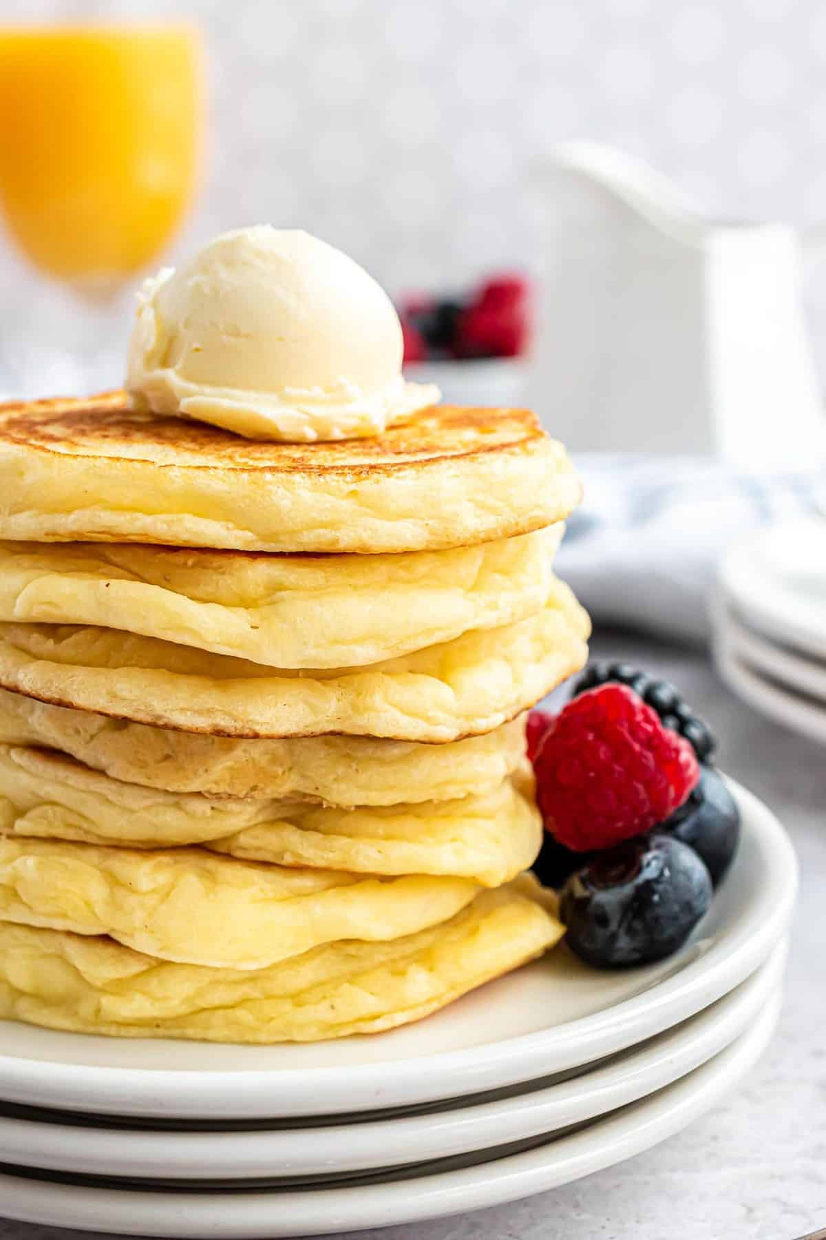 Stack of gluten-free pancakes with a round scoop of butter on top.