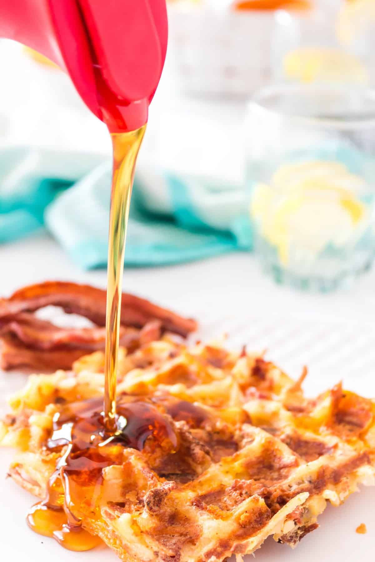 Syrup being poured on a hash brown waffle.