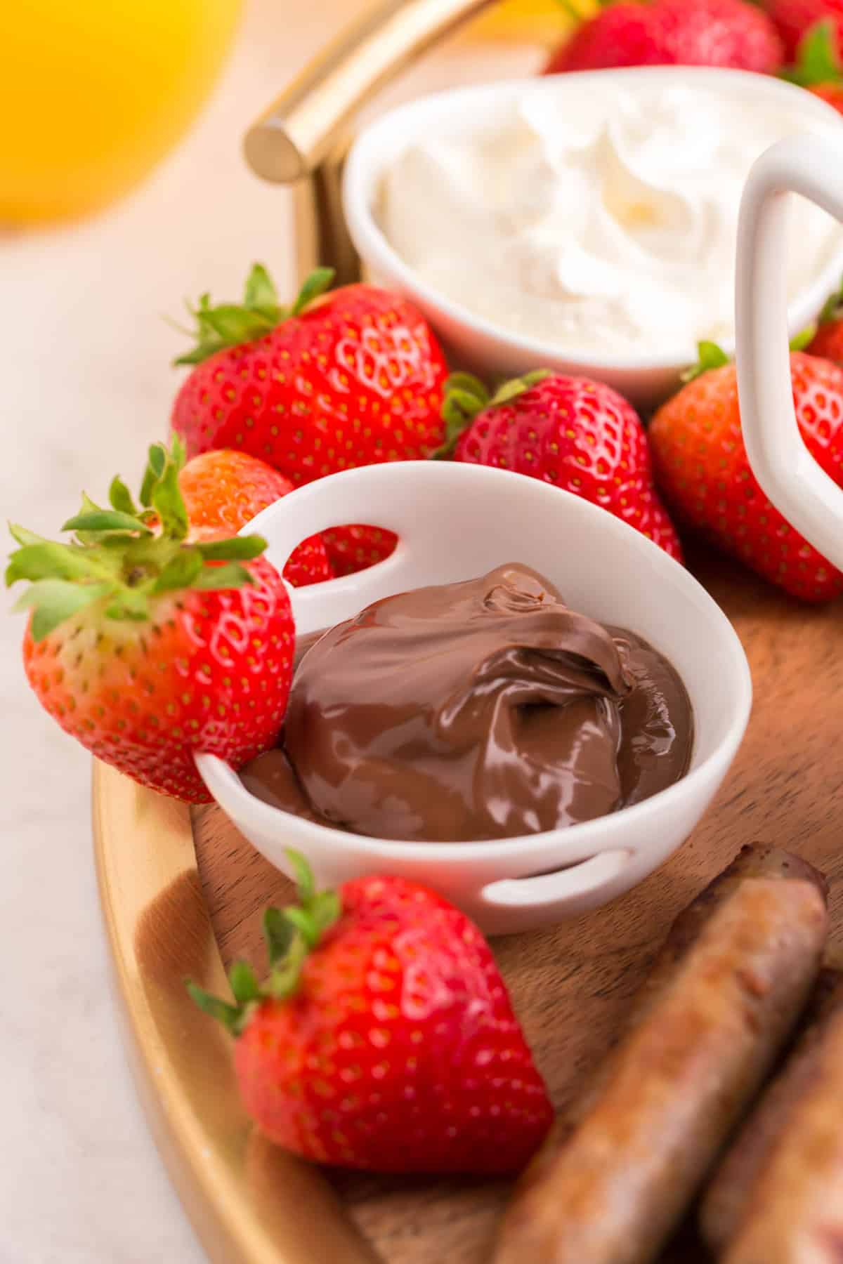 Strawberry on the edge of a bowl of nutella.