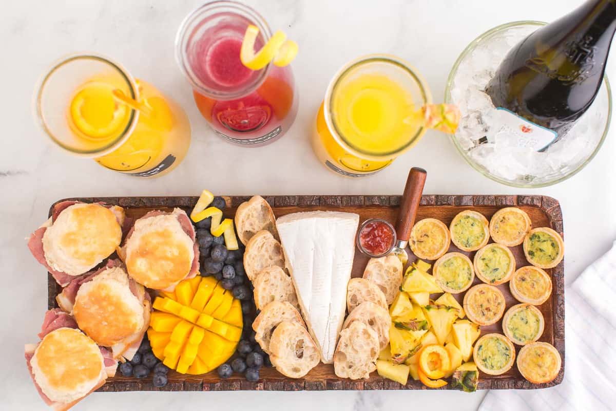 Overhead view of mimosa ingredients and brunch board.