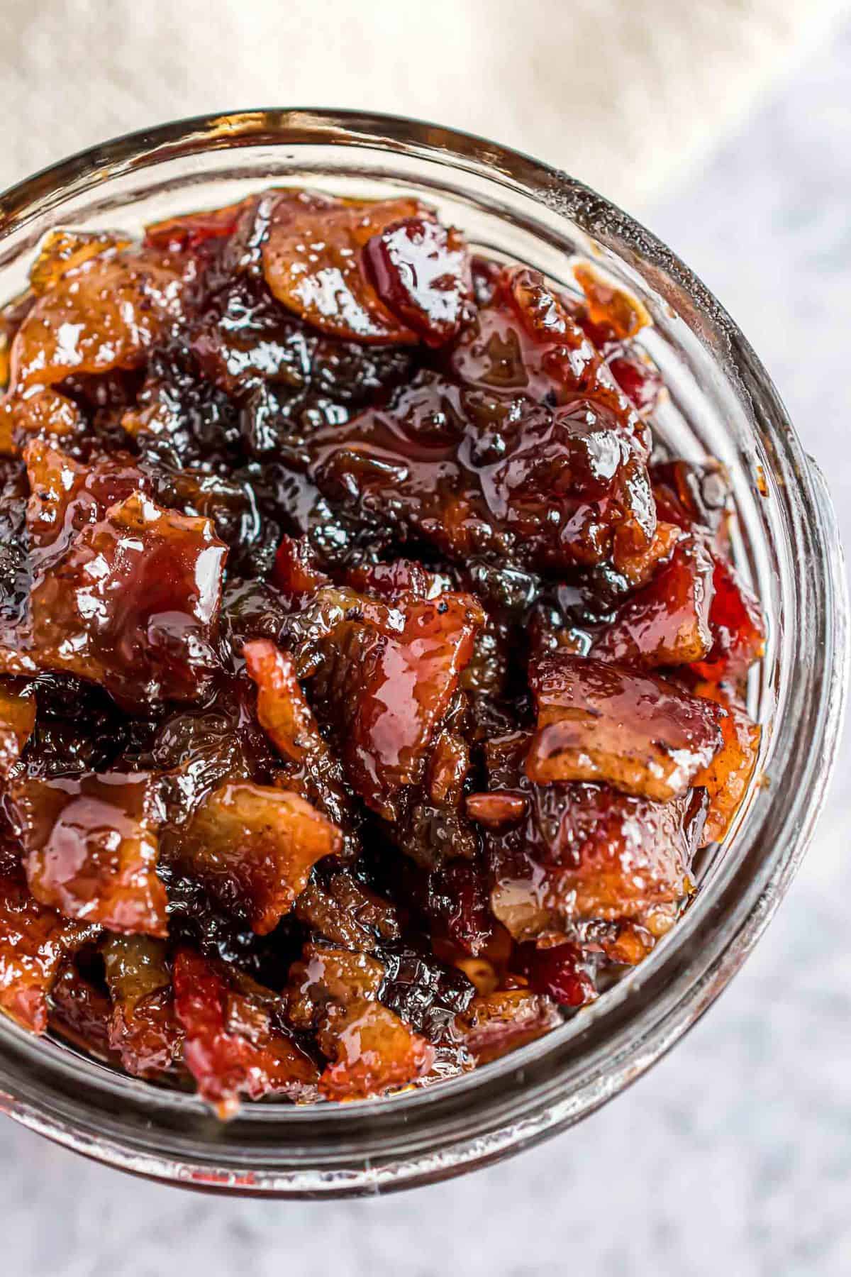 Close up overhead view of bacon jam in a small glass jar.