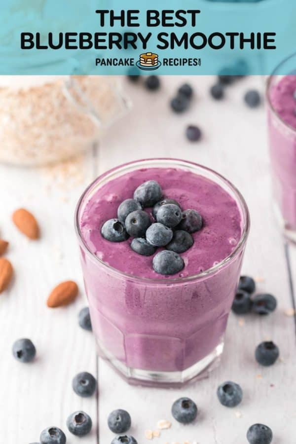 Smoothie topped with blueberries, text overlay reads "the best blueberry smoothie, pancakerecipes.com"
