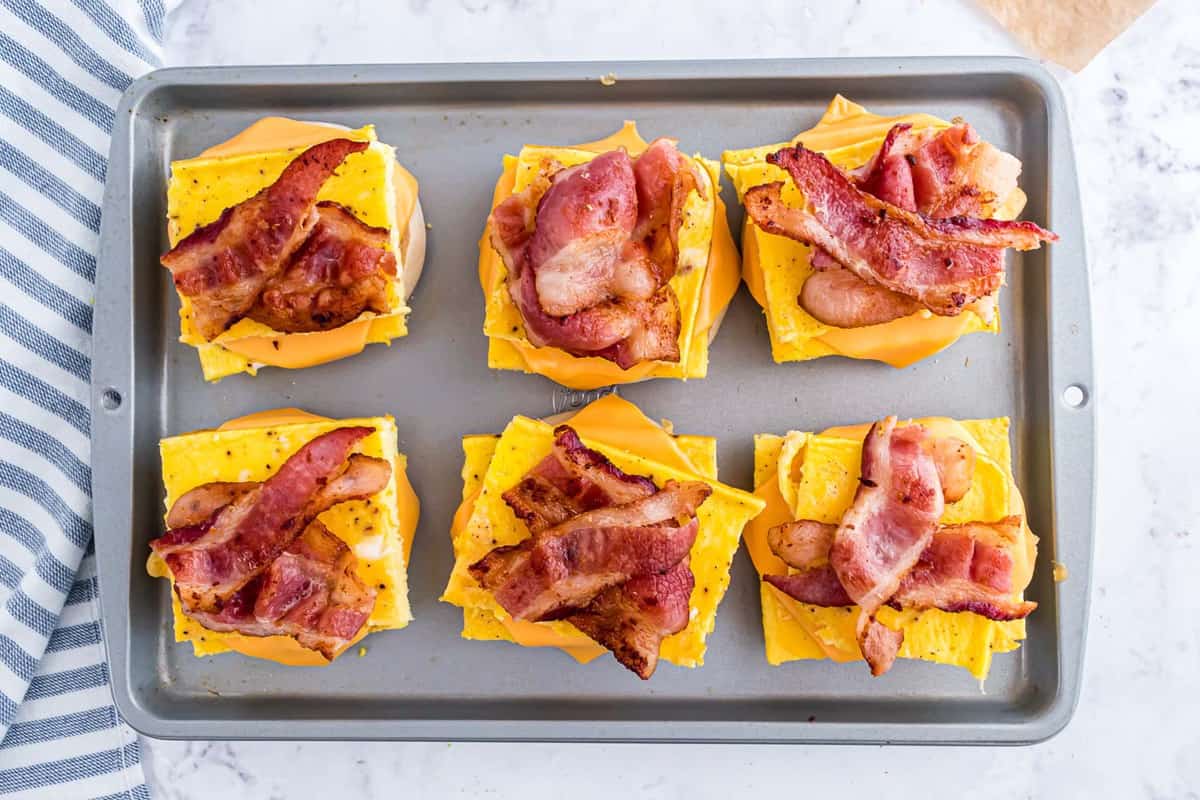 Breakfast sandwiches topped with bacon.