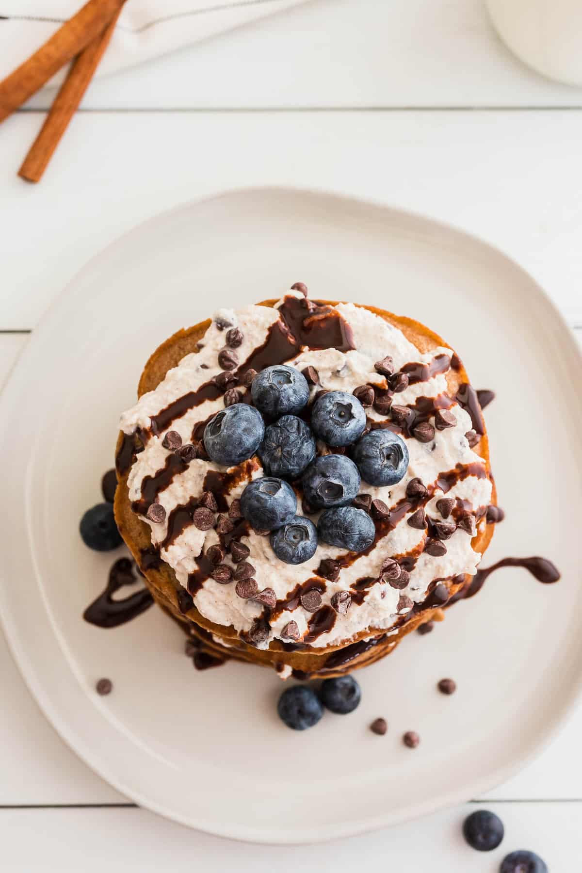 Overhead view of pancake stack topped with blueberries and chocolate chips.