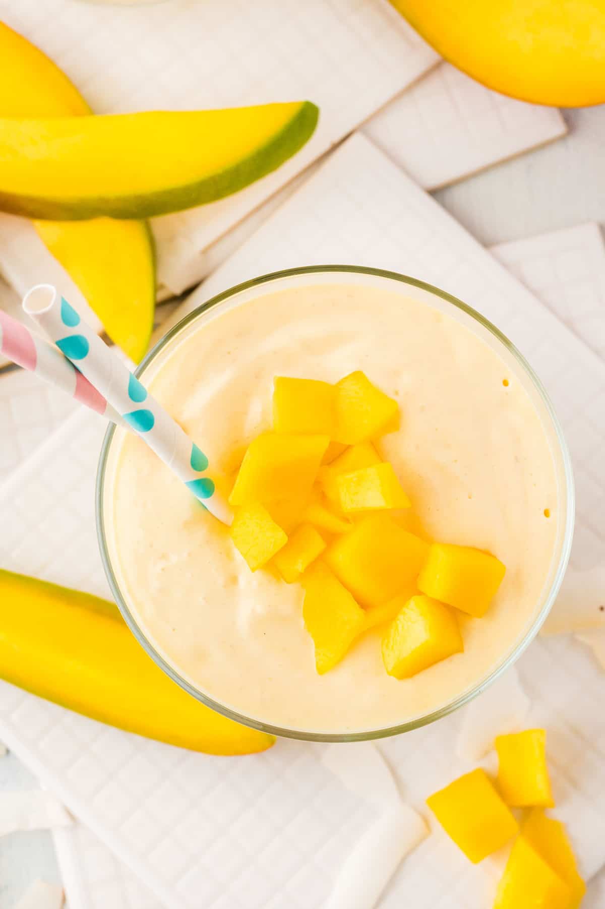 Close up overhead view of a smoothie topped with chopped mango.