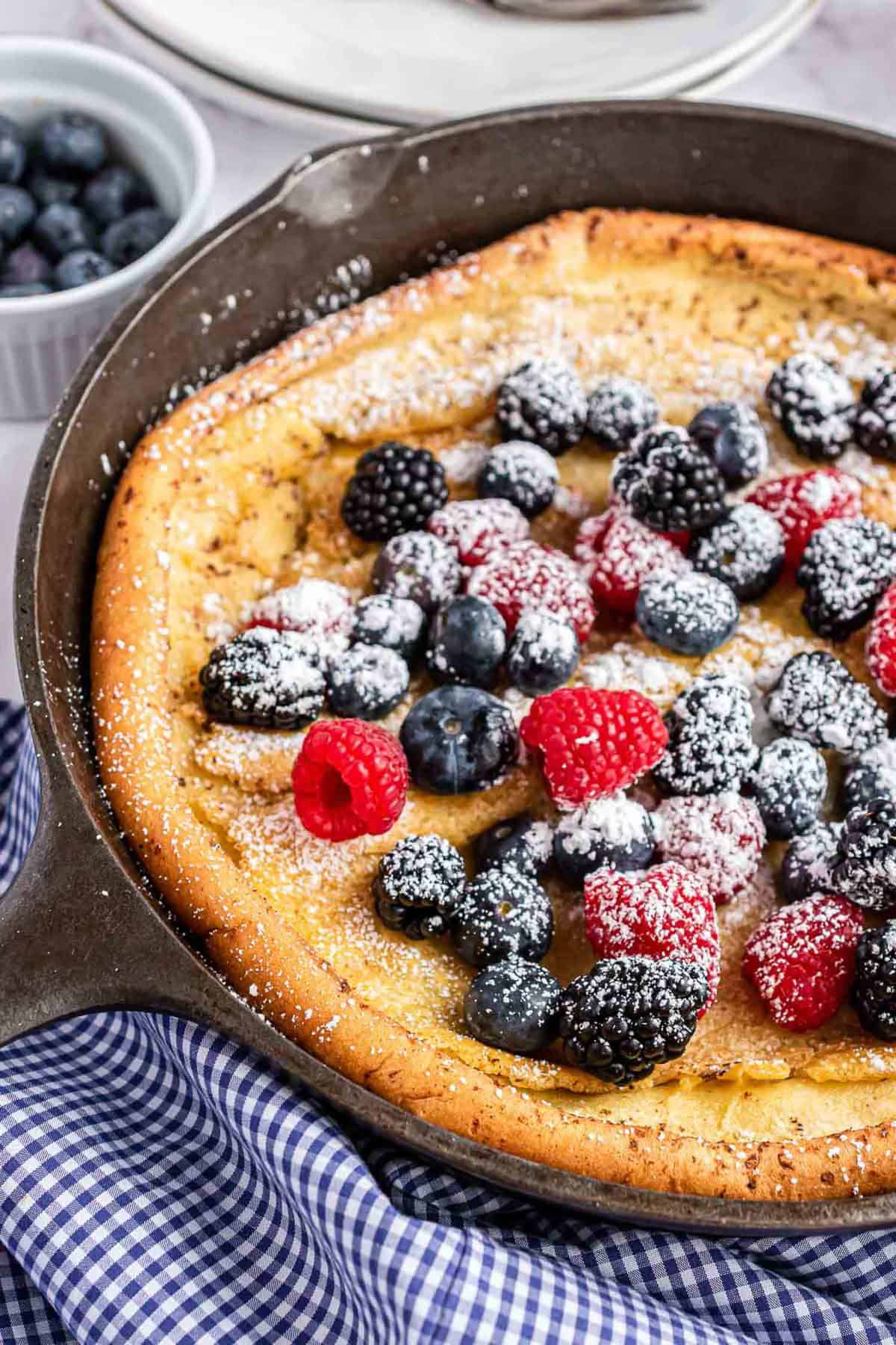 Skillet pancake with fresh berries and powdered sugar.