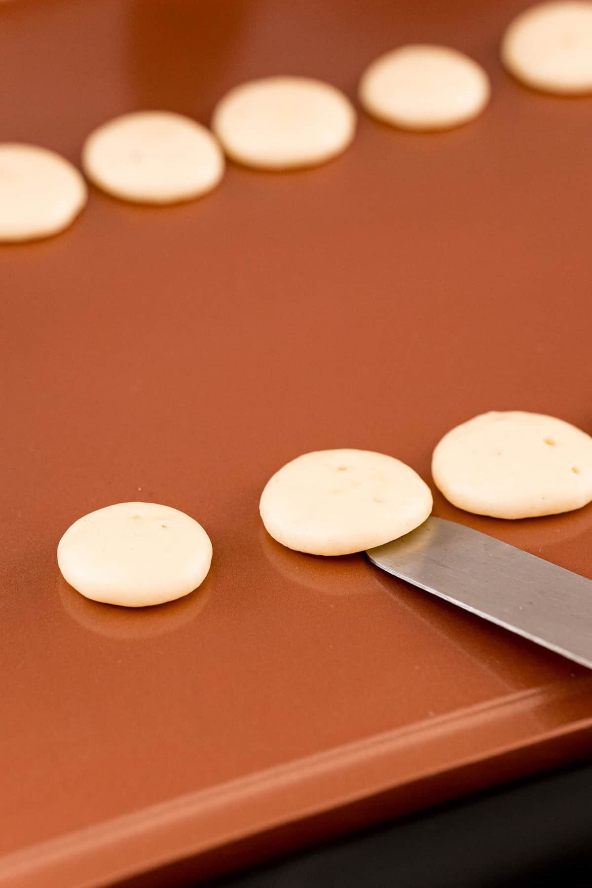 Offset spatula flipping mini pancakes.