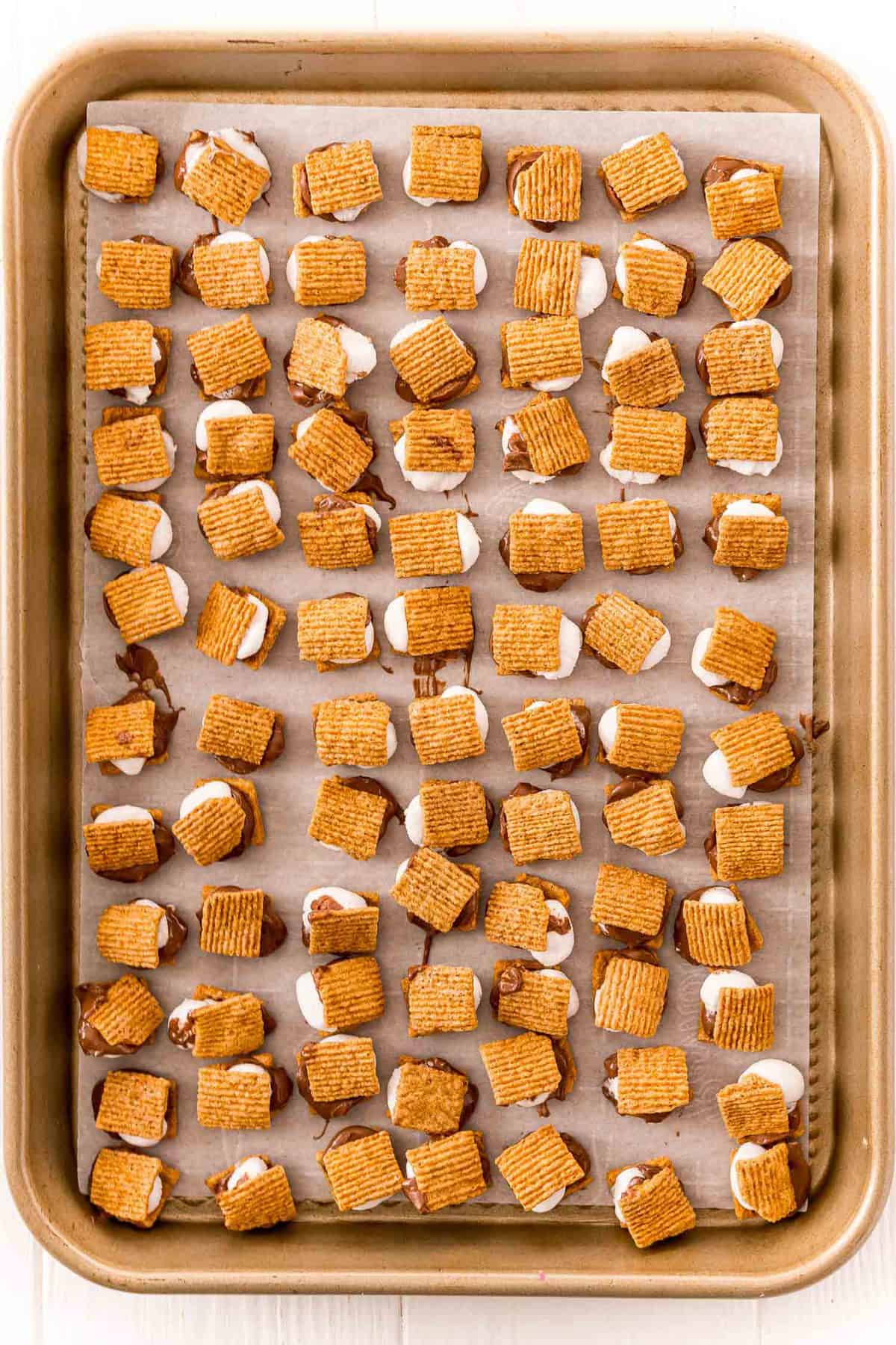 Tiny s'mores on a baking sheet.