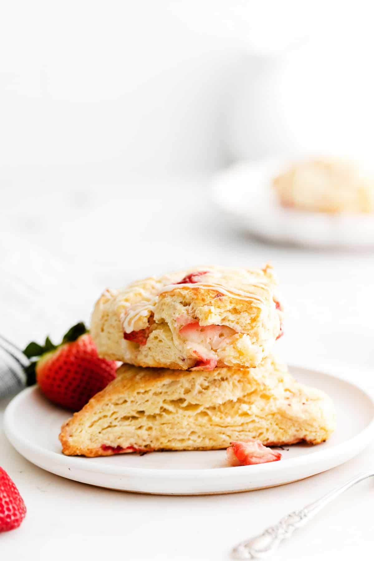 Two strawberry scones stacked on a plate.
