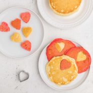 Red and white pancakes with heart-shaped cut outs.