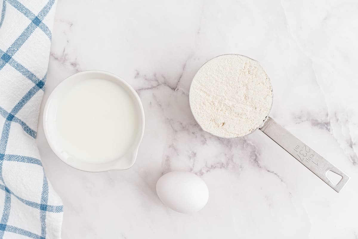 Overhead view of pancake mix, egg, and milk.