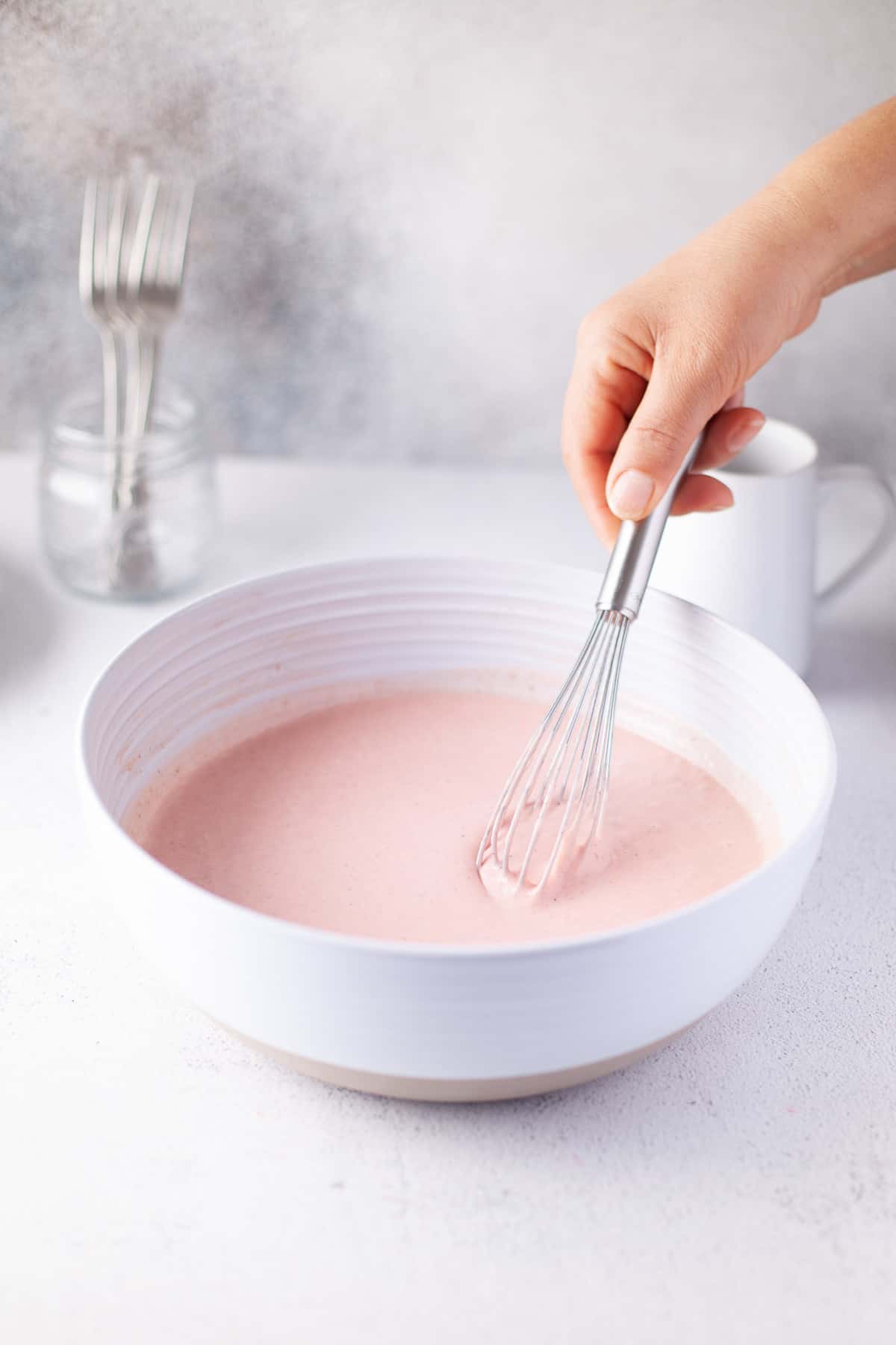 Pink batter being whisked.