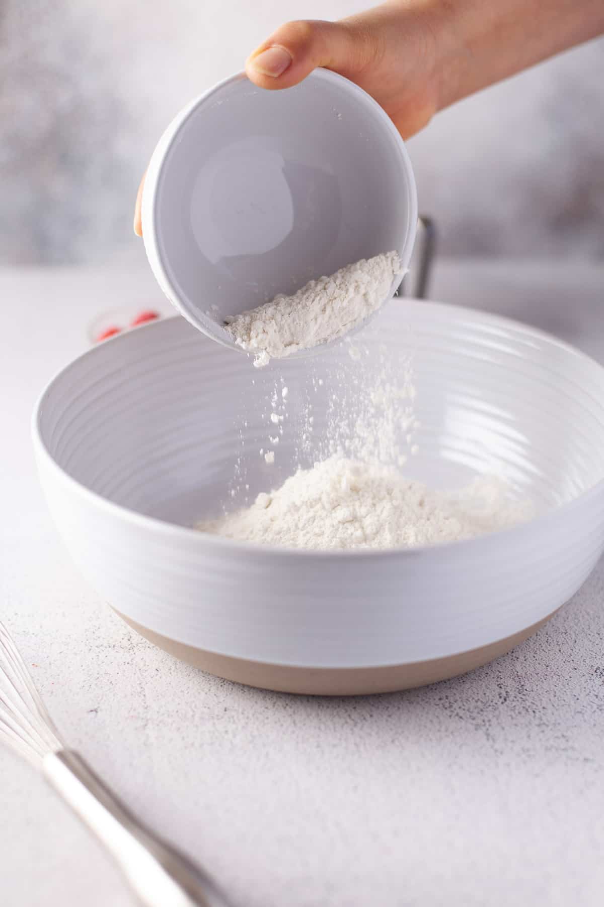 Dry ingredients being added to a bowl.