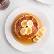 Overhead view of pancakes topped with banana slices.