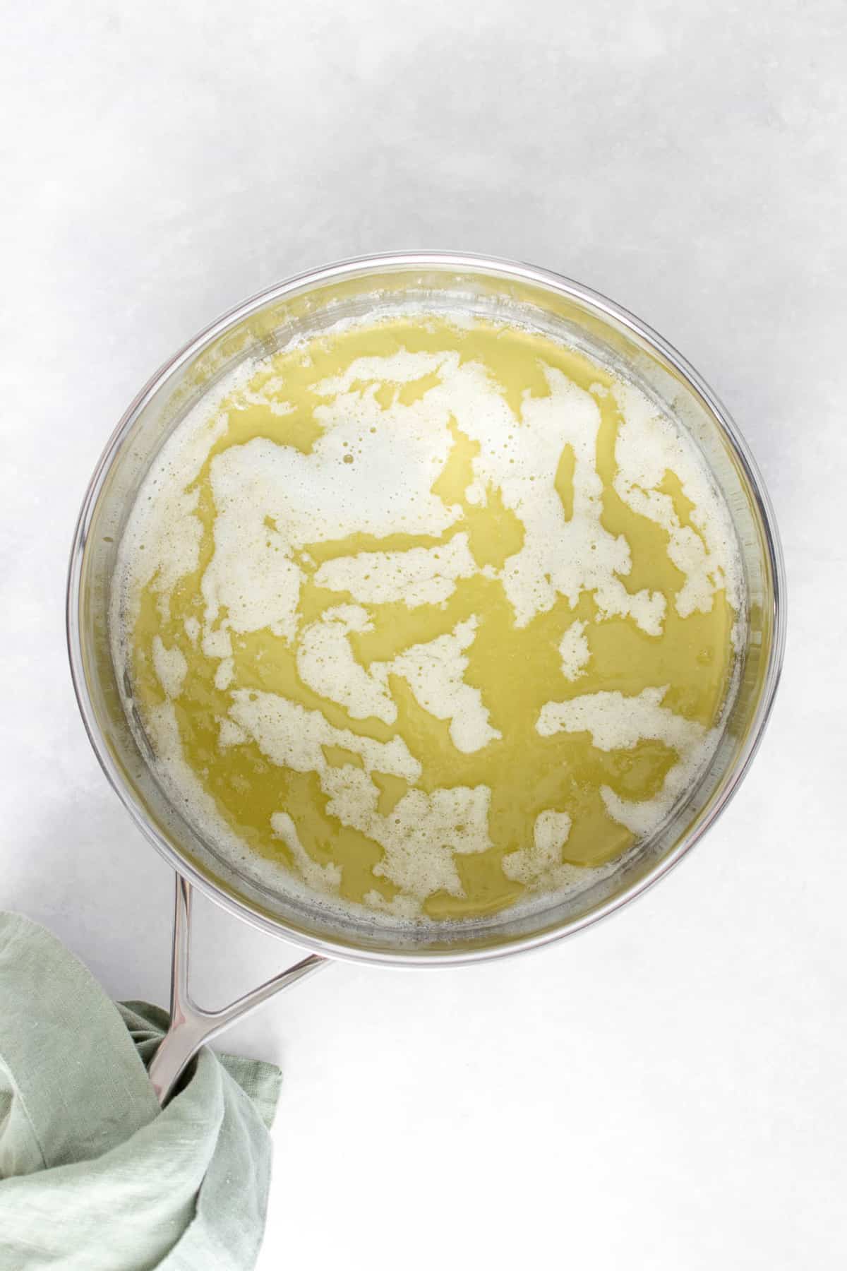 Melted butter in a stainless steel pan.