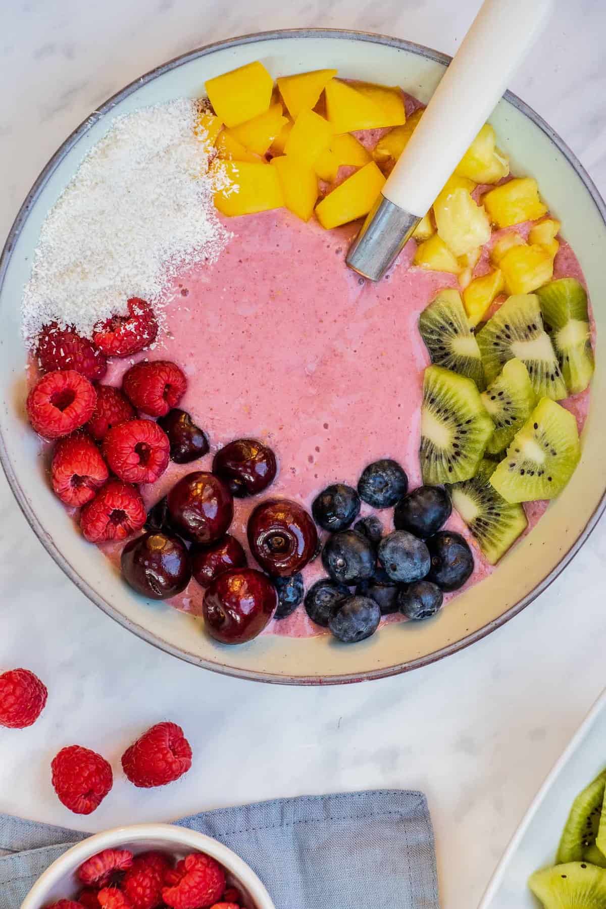 Smoothie bowl with a spoon and colorful toppings.