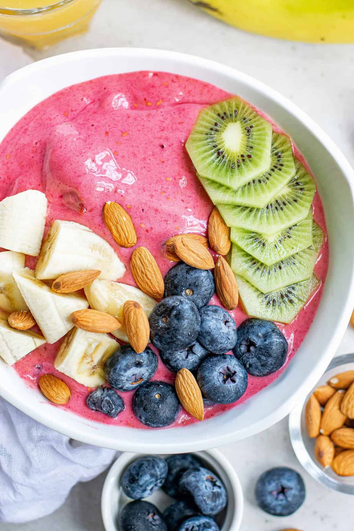 Raspberry smoothie bowl with toppings.