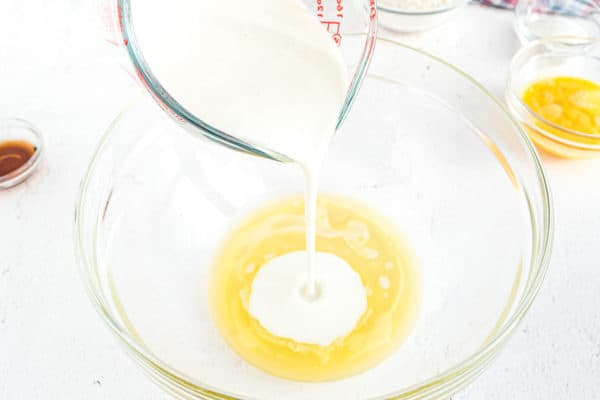 Buttermilk being poured into butter in a clear bowl.