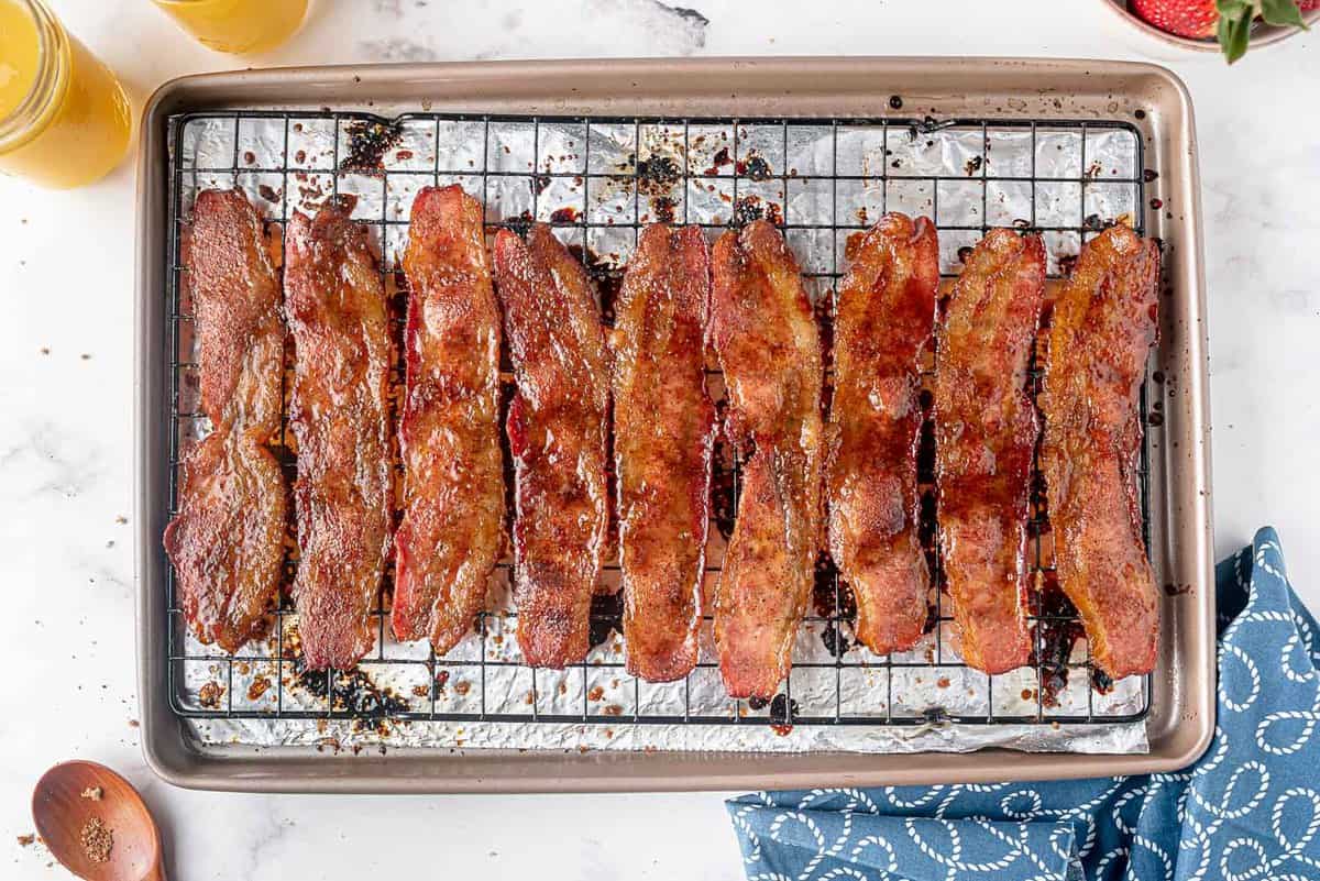 Cooked, candied bacon on a wire rack on a sheet pan.